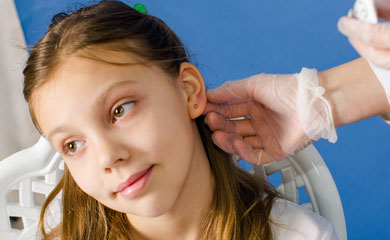 Обработка уха после процедуры прокола ушей